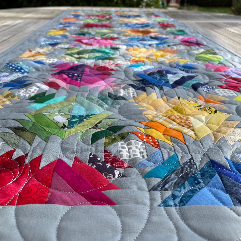 Happy Scrappy Pineapple Quilt im Garten bei schönem Wetter